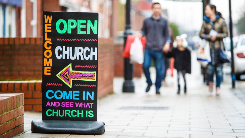 Colourful street sign point to church