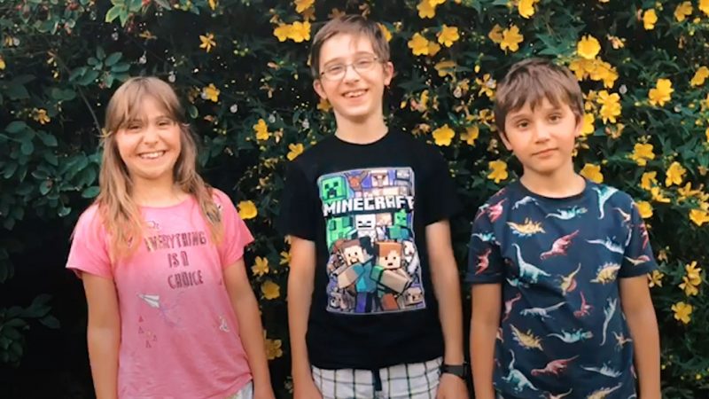 Three smiling children from the congregation