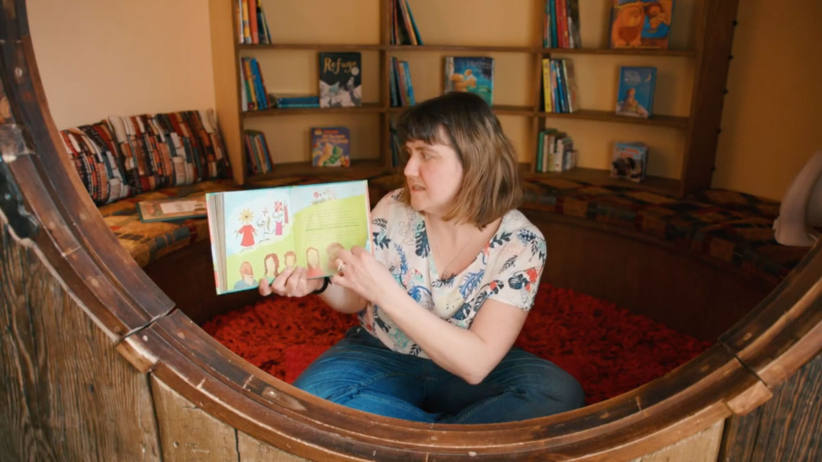 The storyteller turns a page of the book